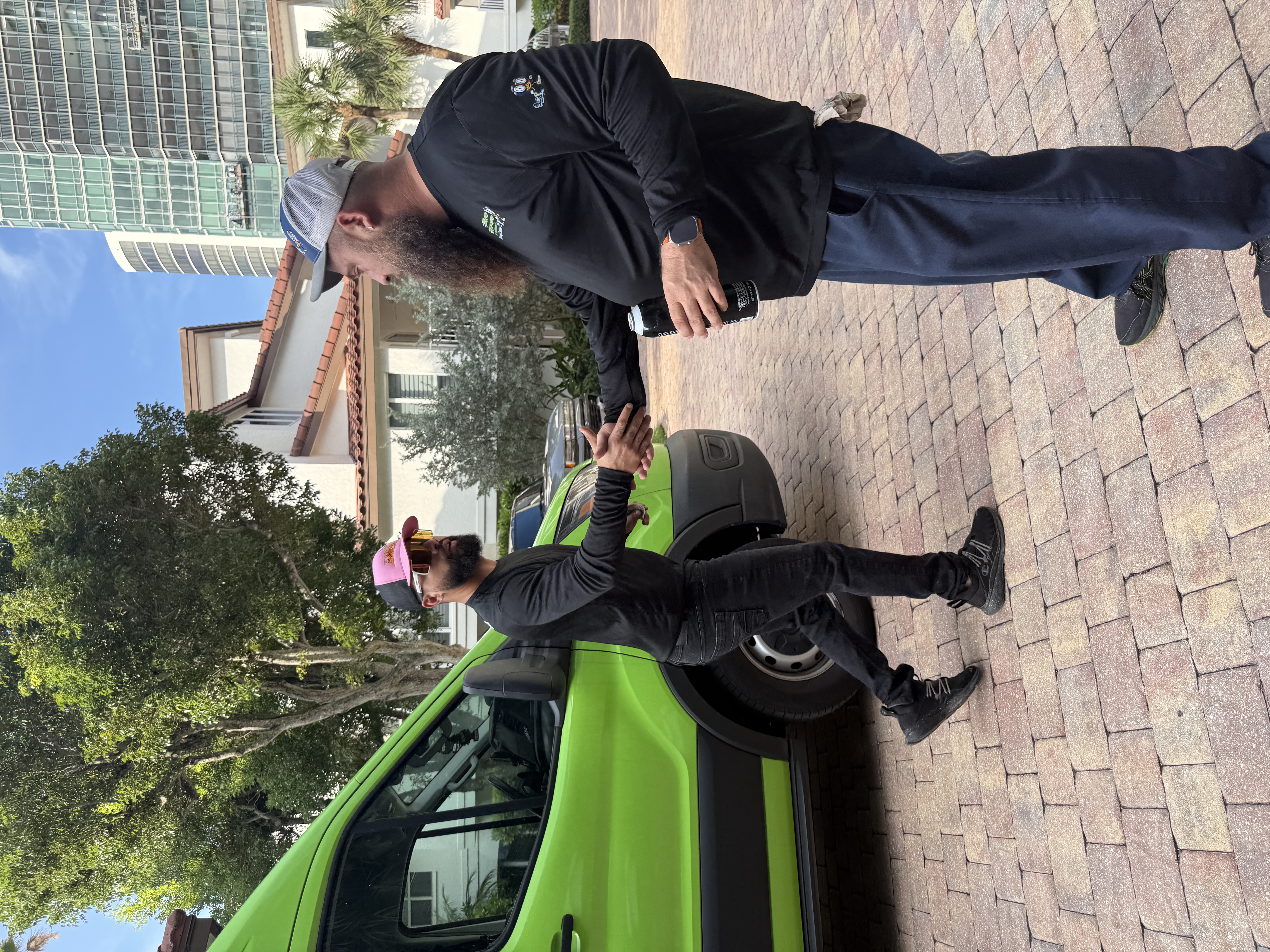 Rapid Response AC technician and homeowner shaking hands in front of the branded green service van